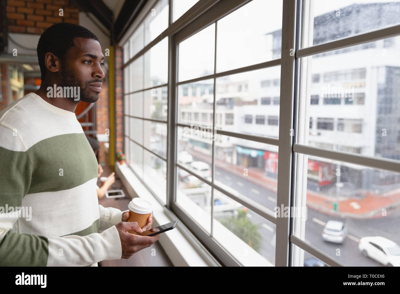 Businessman using mobile phone in office canteen Banque D'Images