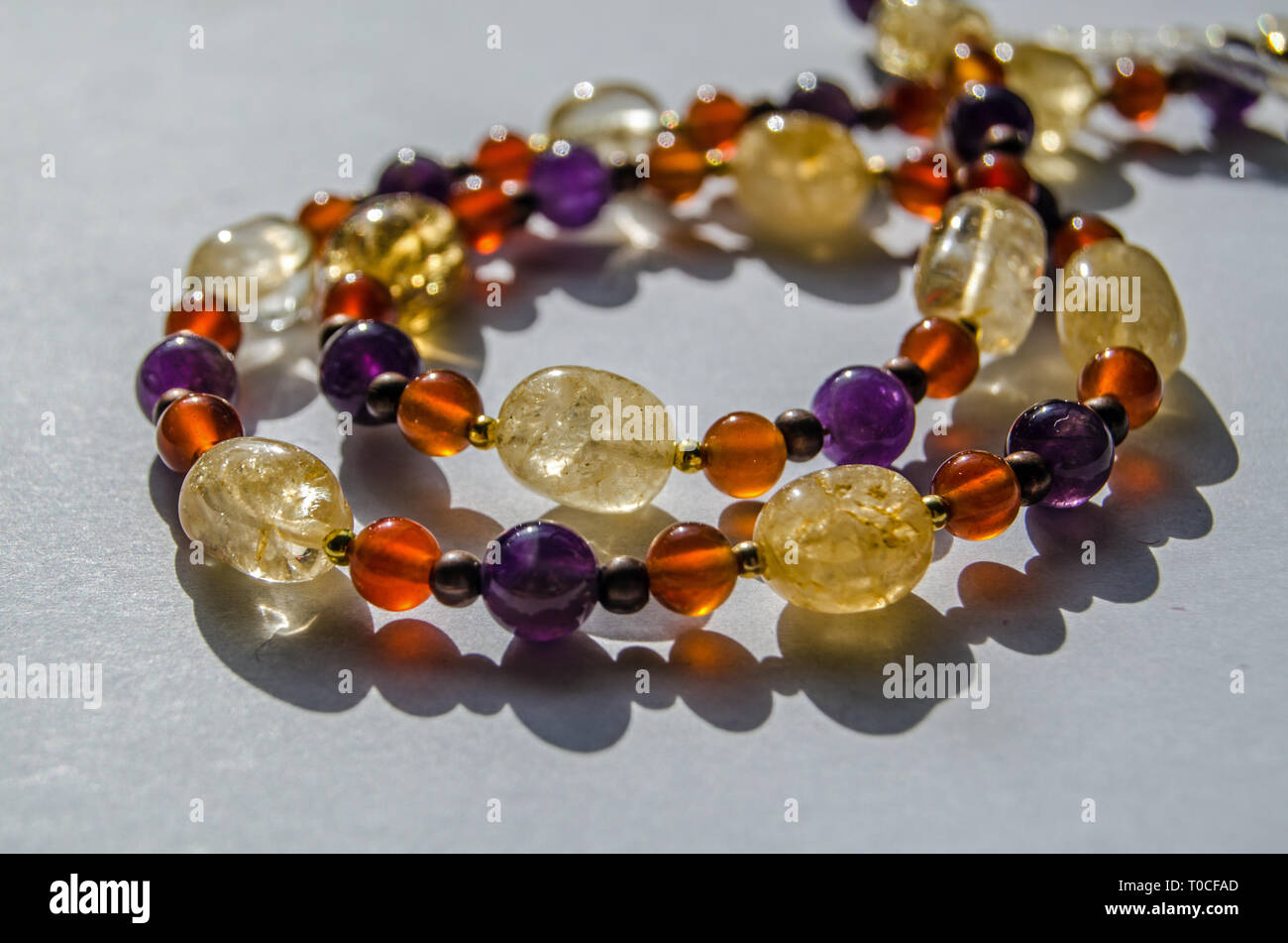 Fait main Bracelet et collier couleurs à l'aide de perles de pierre gemme semi-précieuse dont jaune, citrine améthyste violette et orange cornaline. Banque D'Images