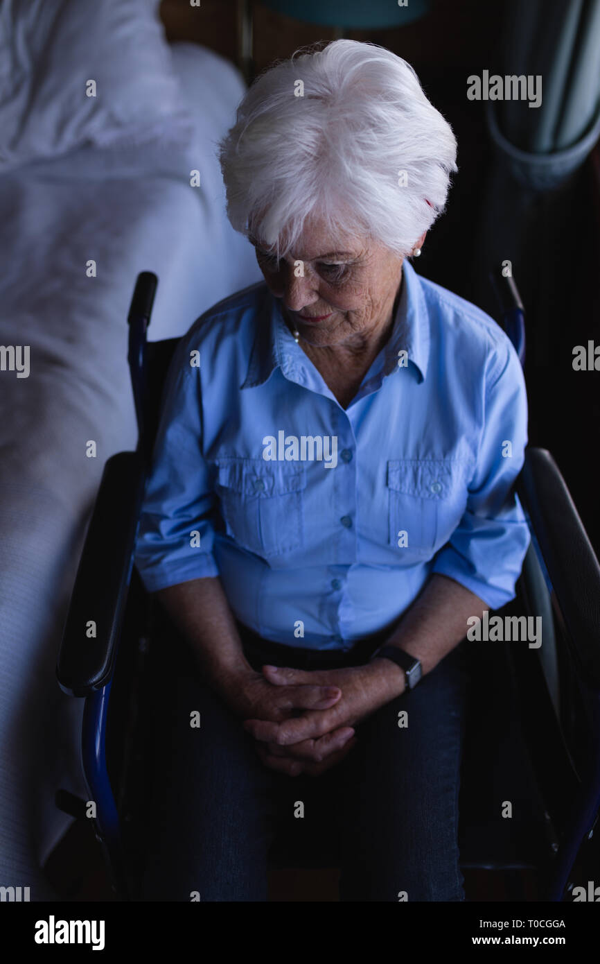 Mobilité active senior woman with hand clasped sitting sur fauteuil roulant dans la chambre à la maison Banque D'Images