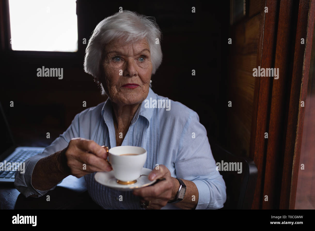 Thoughtful senior woman alors que le café à la maison Banque D'Images