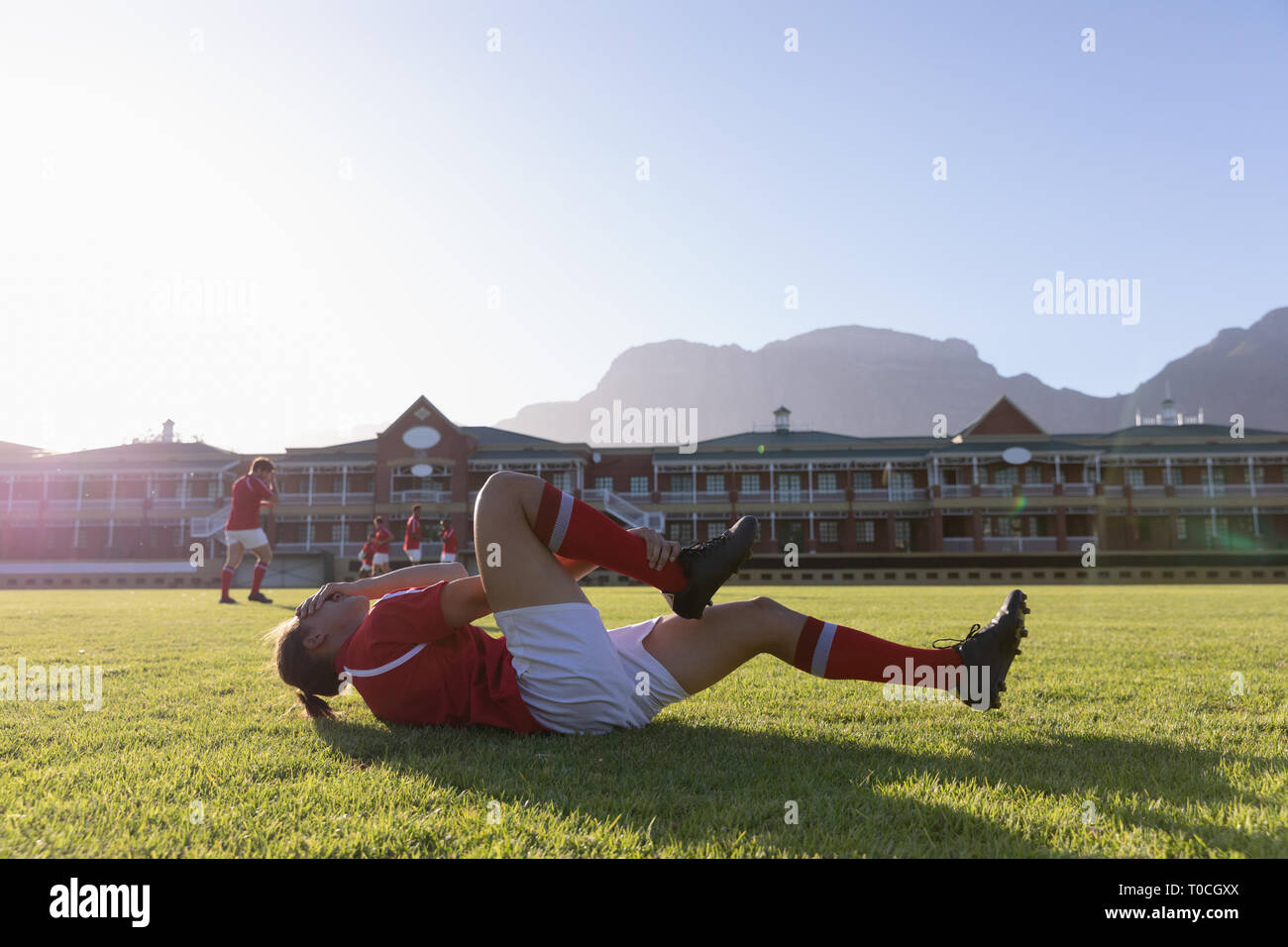 Joueur de rugby homme blessé gisant sur le sol Banque D'Images