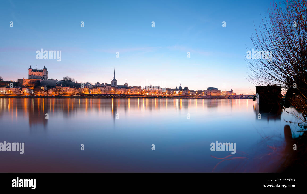 Vue panoramique de la ville de Saumur à partir de l'ensemble de la Loire au coucher du soleil, avec le château médiéval et la vieille ville avec l'église Saint-Pierre. Banque D'Images