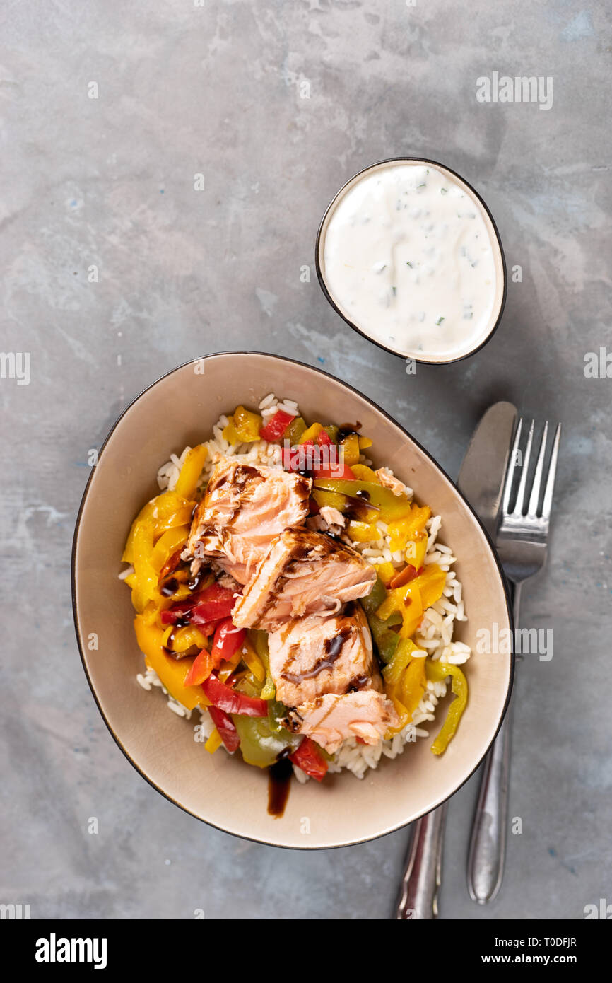 Saumon au four avec des légumes dans une assiette sur fond clair. Shot verticale Banque D'Images