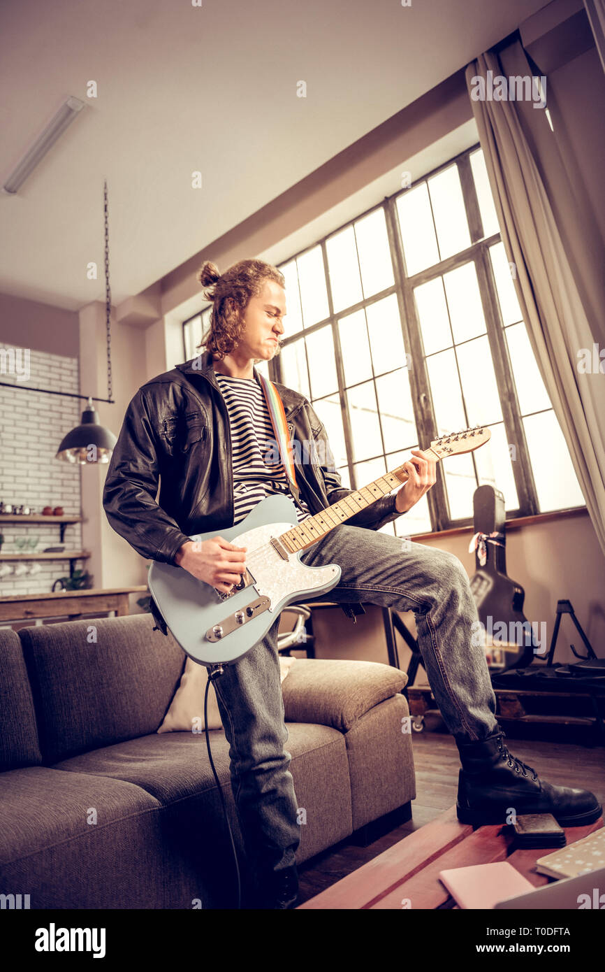 Musicien avec cheveux bun obtenir beaucoup de satisfaction jouer de la musique rock Banque D'Images