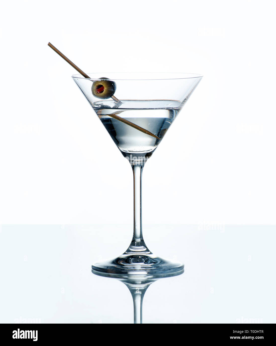 Dry Martini avec olive verte dans verre à cocktail sur fond blanc avec la  réflexion. Boire de l'alcool de luxe sur le comptoir du bar Photo Stock -  Alamy