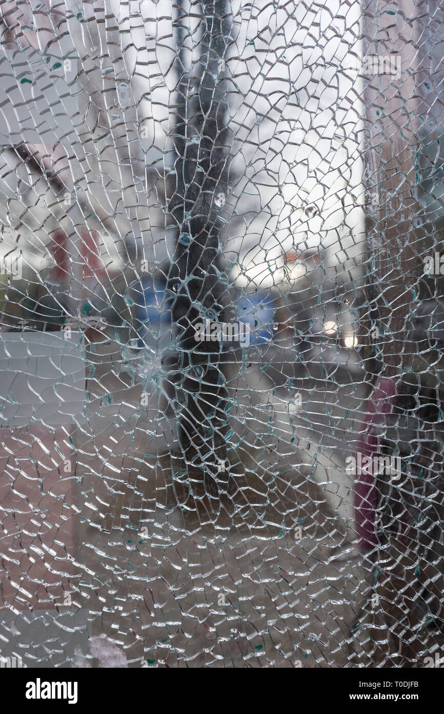 Close-up of a broken et verre brisé volet ou une fenêtre, vue sur la ville floues en arrière-plan. Banque D'Images