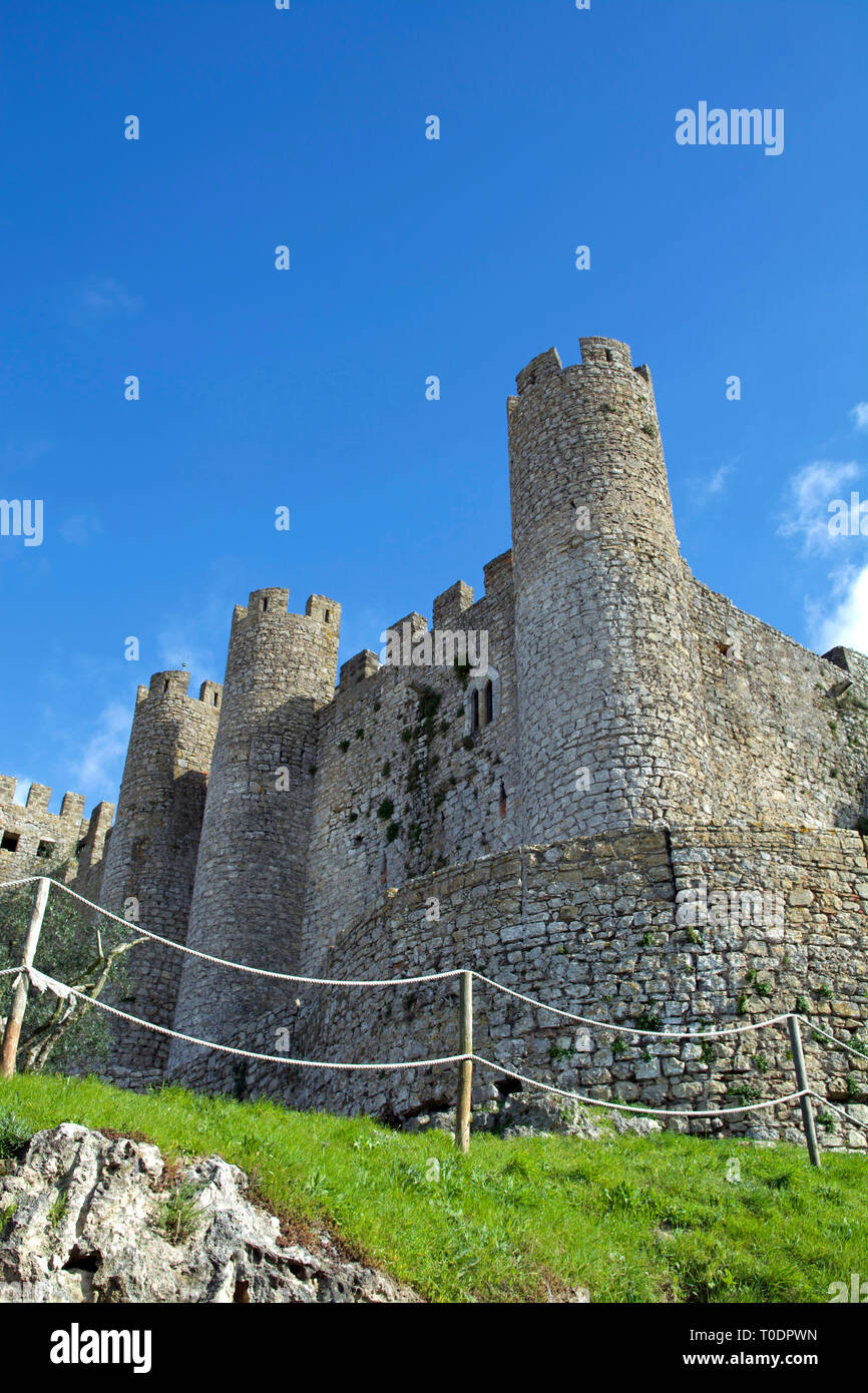 Vue partielle de l'imposant château médiéval d'Obidos dans le centre du Portugal sous un ciel bleu ensoleillé. Banque D'Images