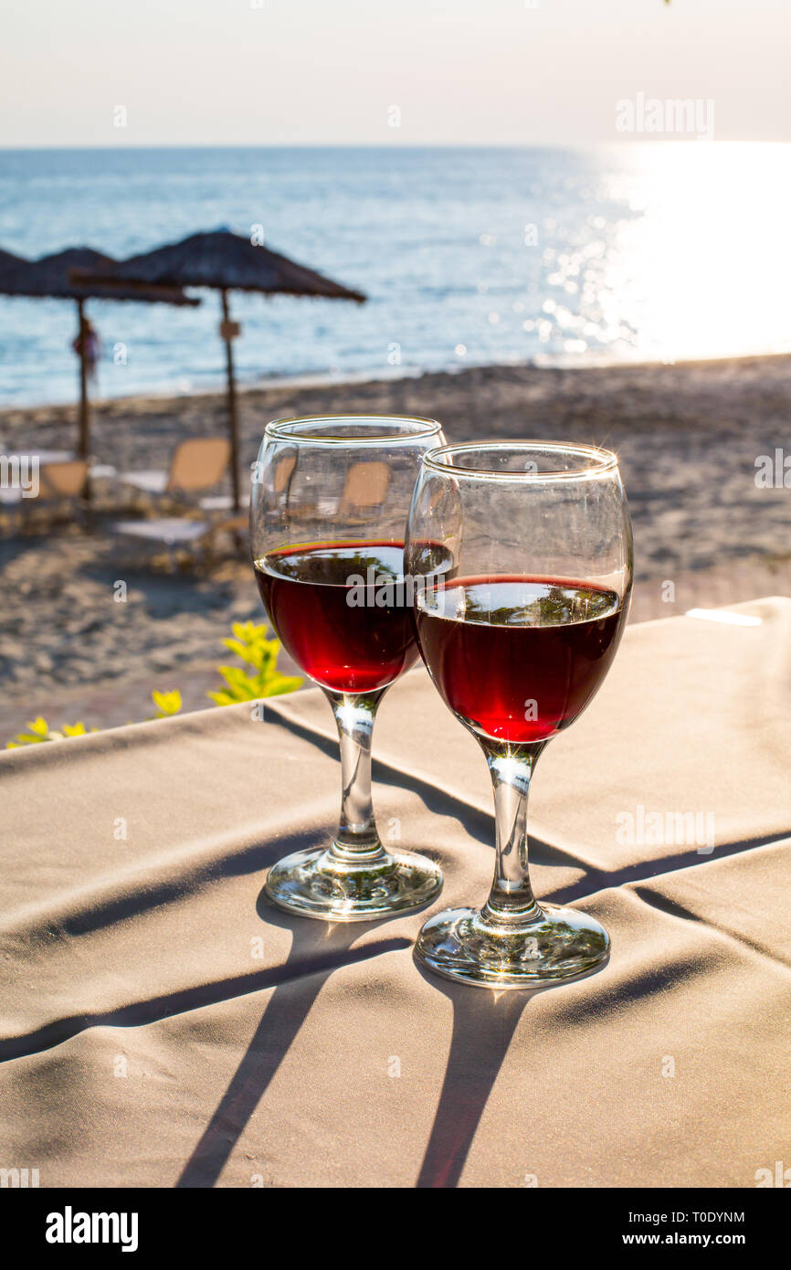 Deux verres de vin rouge, avec la mer, coucher de soleil sur la plage de  réflexion à l'arrière-plan. L'été vacances Photo Stock - Alamy
