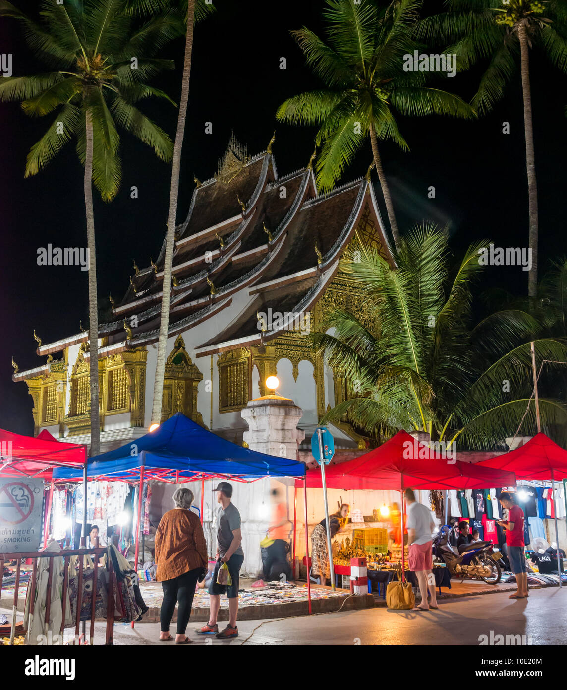 Shopping pour les souvenirs touristiques au marché nocturne avec temple illuminé, Luang Prabang, Laos, Asie du sud-est Banque D'Images