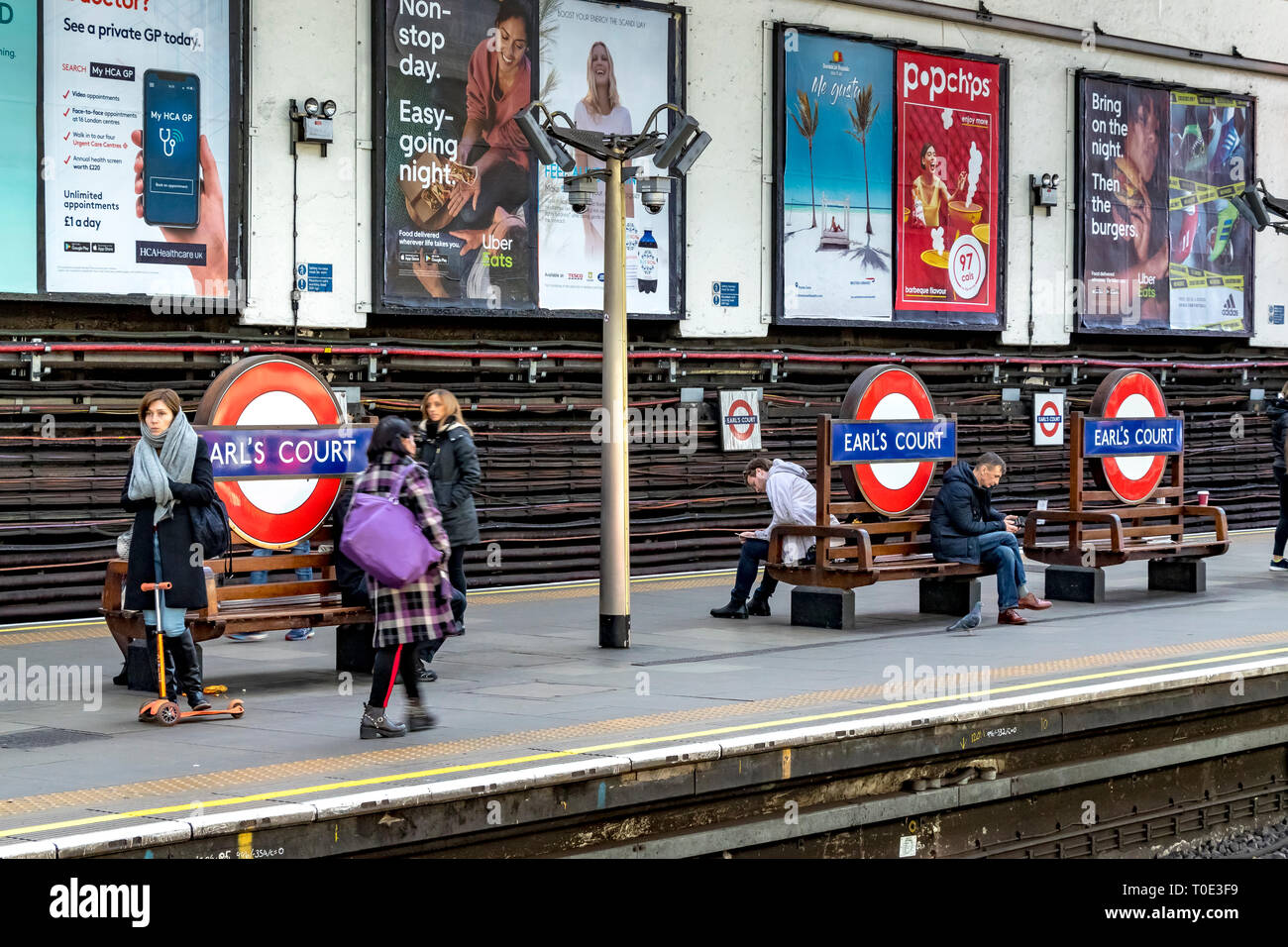 Personnes attendant sur la plate-forme pour un train District Line à la station de métro Earls court, Londres, Royaume-Uni Banque D'Images