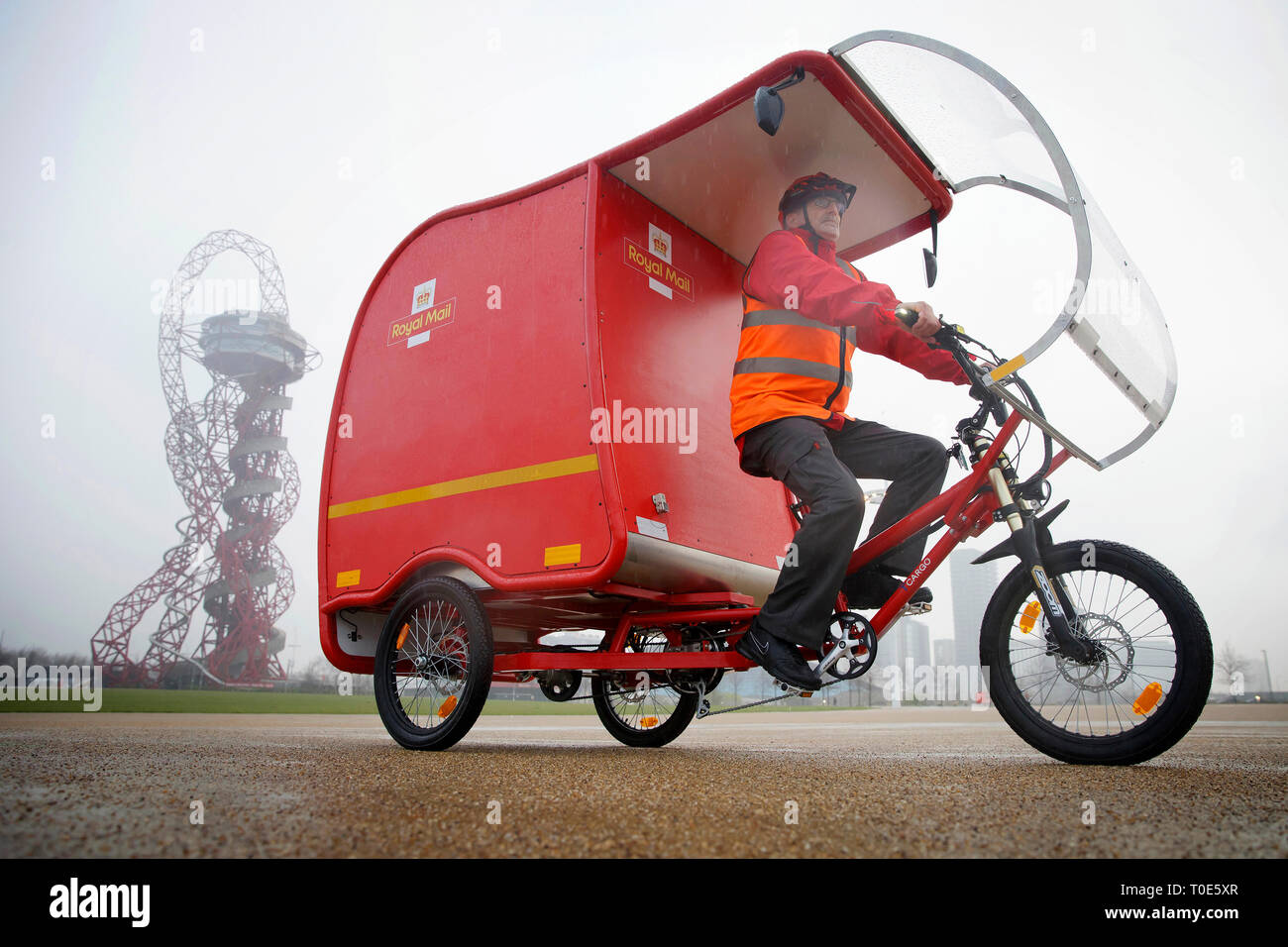 Utilisez uniquement rédactionnel Postman Nigel Roughty devant l'ArcelorMittal Orbit à l'occasion du dévoilement de l'émission zéro carbone e-Trikes, qui sont essentiellement alimenté par une combinaison de l'énergie solaire, batterie et technologie de freinage, et sera à l'essai par Royal Mail à Stratford dans l'Est de Londres, Cambridge et Sutton court à la fin du mois. Banque D'Images