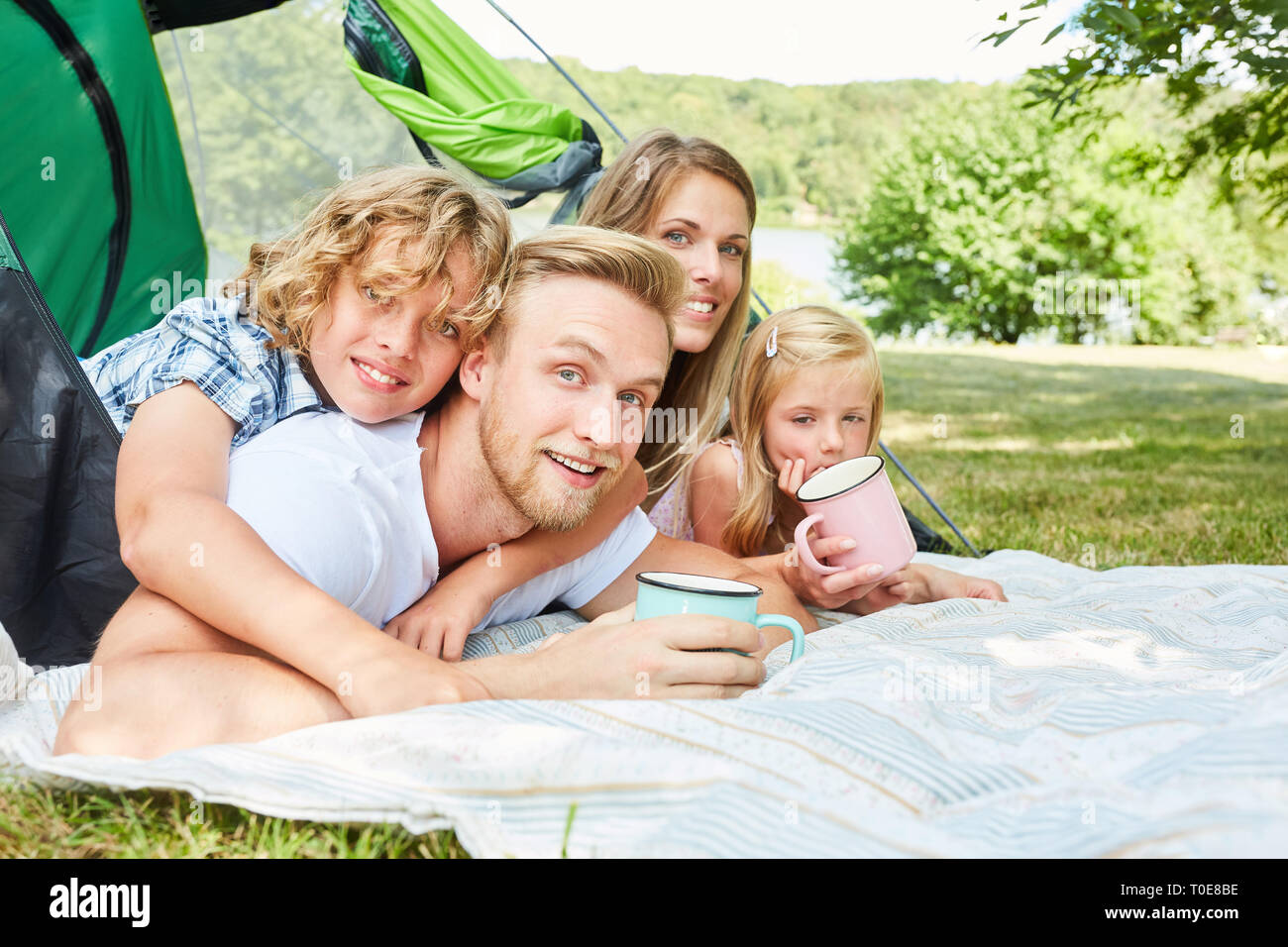 Famille heureuse avec deux enfants en camping dans la nature en vacances d'été Banque D'Images