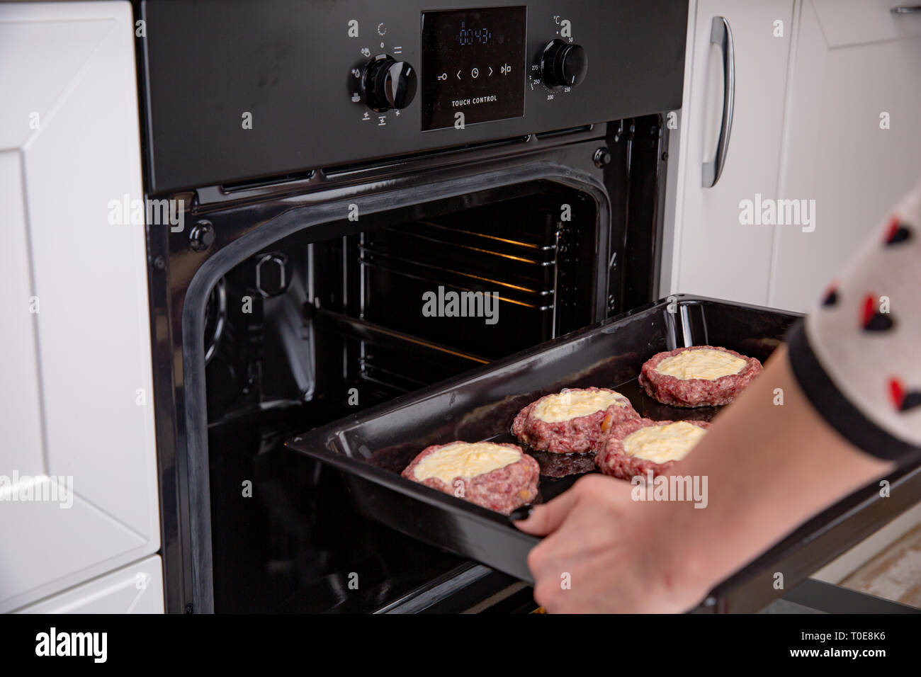 Femme mains mettre la plaque de cuisson avec des boulettes de viande et en  escalopes ou four. Cours de cuisine à domicile Photo Stock - Alamy