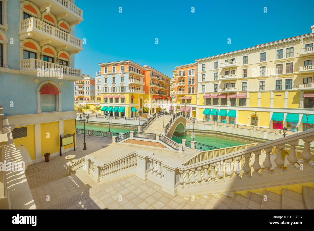 Grand escalier menant à un pont vénitien sur les canaux de la ville pittoresque de Qanat Quartier icône de Doha, au Qatar, en une journée ensoleillée avec ciel bleu. Venise à la Banque D'Images