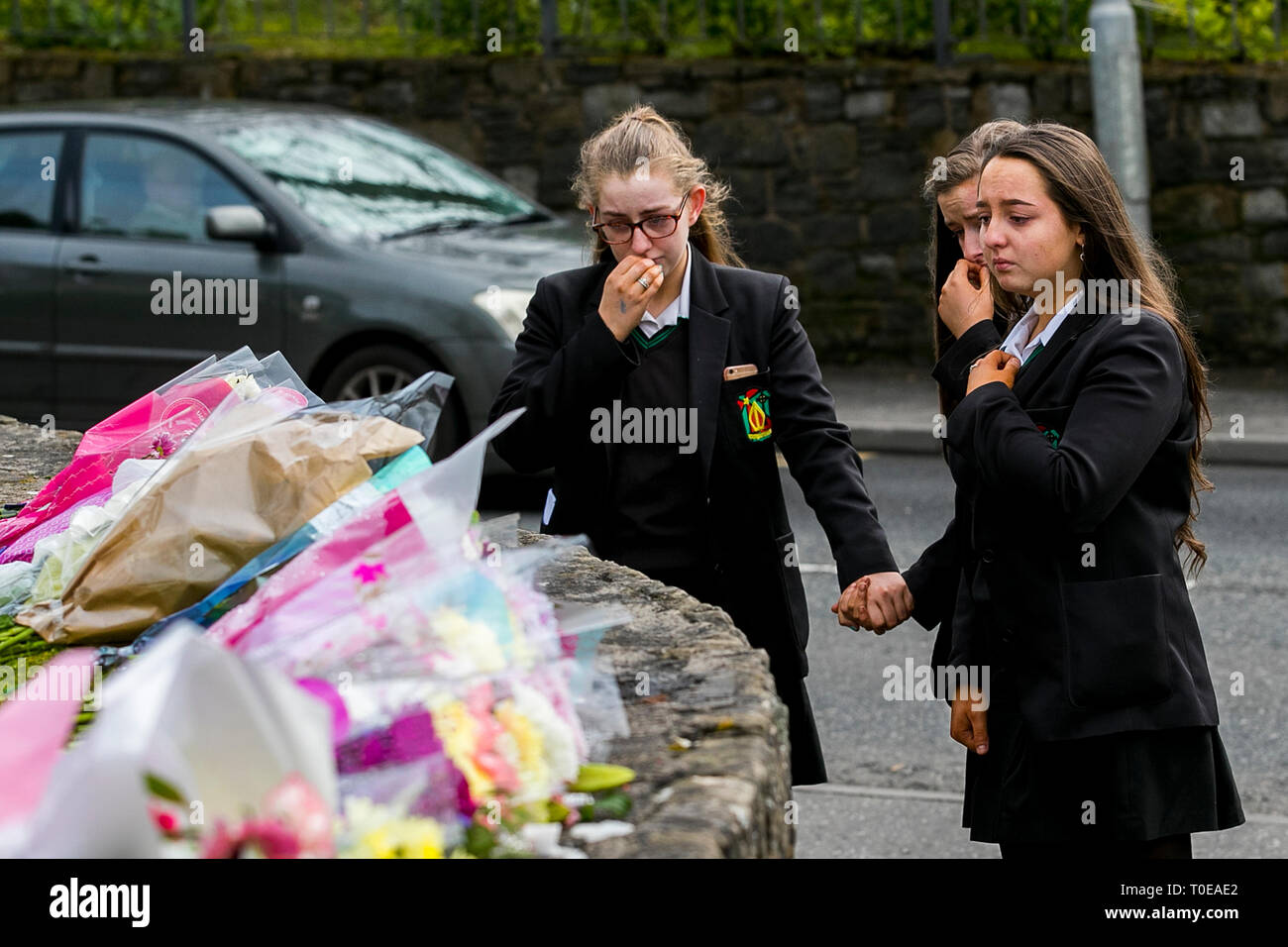 Les élèves de la Holy Trinity College laisser tributs floraux à l'extérieur de l'hôtel Greenvale à Cookstown, Co. de Tyrone, en Irlande du Nord après la mort de trois adolescents, Lauren Bullock, Connor Currie, et Morgan Barnard, lors d'une partie de la St Patrick. Banque D'Images