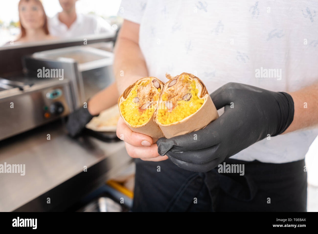 Chef en camion alimentaire montrant un burrito Banque D'Images