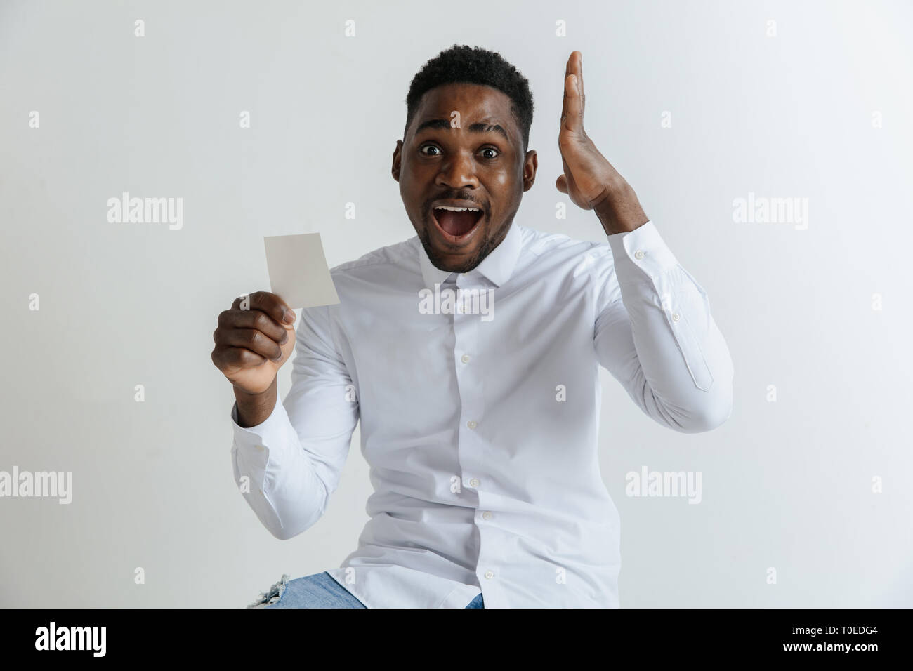 Les jeunes afro homme avec une expression heureuse surprise a gagné un pari  sur fond gris studio. Les droits de l'émotions faciales et paris concept  Photo Stock - Alamy