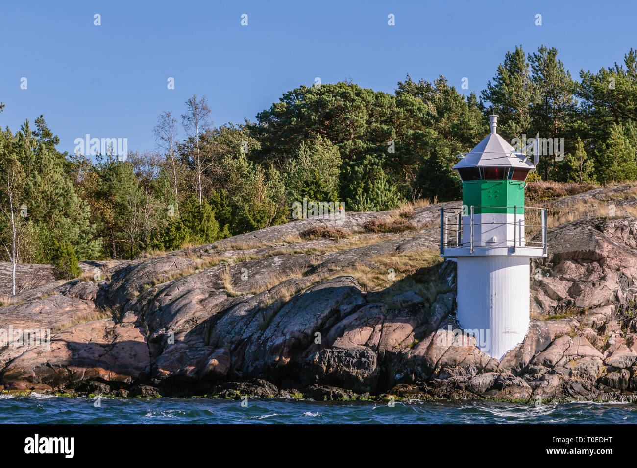 Phare dans la mer Baltique à la côte rocheuse de la Suède Banque D'Images