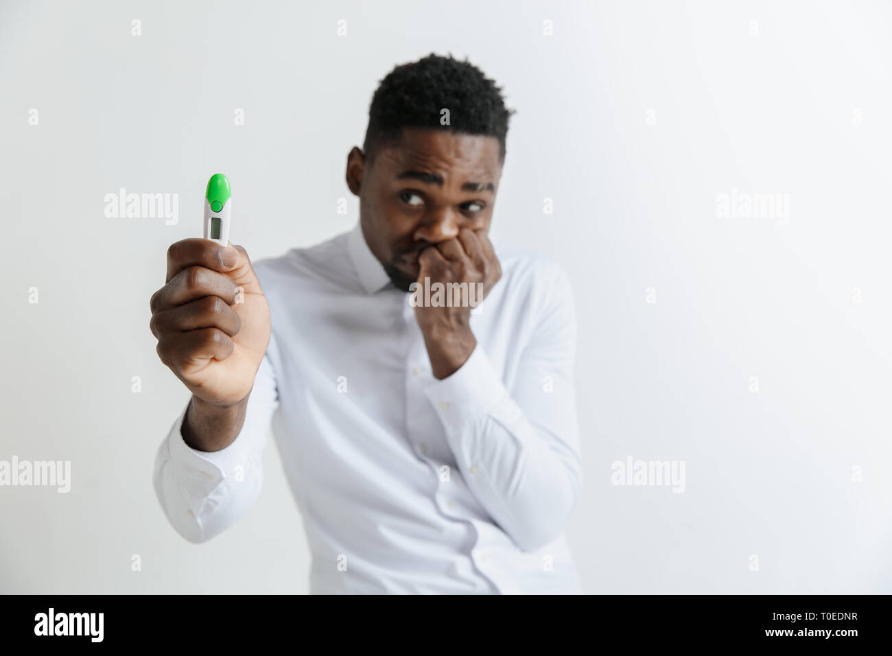 Les jeunes mécontents african american man looking at test de grossesse. Bel homme triste et frustré d'avoir des problèmes. Guy déprimée car de résultat de test de grossesse Banque D'Images