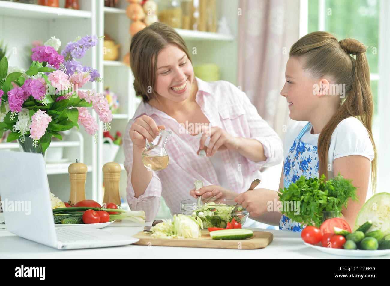 Portrait de funny girls préparer une salade fraîche Banque D'Images
