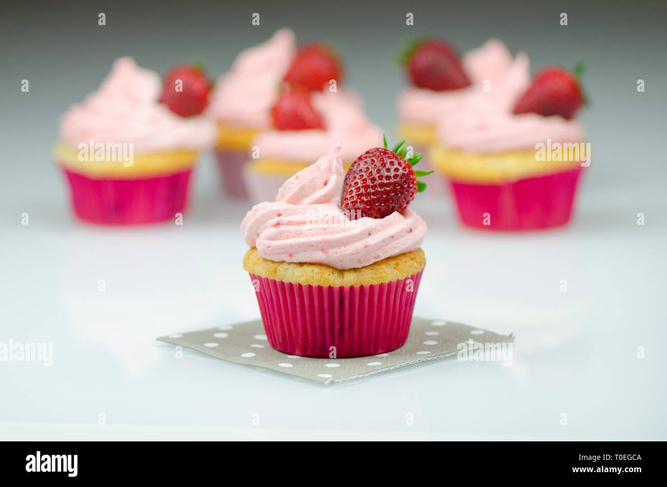 Délicieux cupcake fraise rose avec une fraise. Cupcakes et rose cerise avec une fraise sur le dessus Banque D'Images