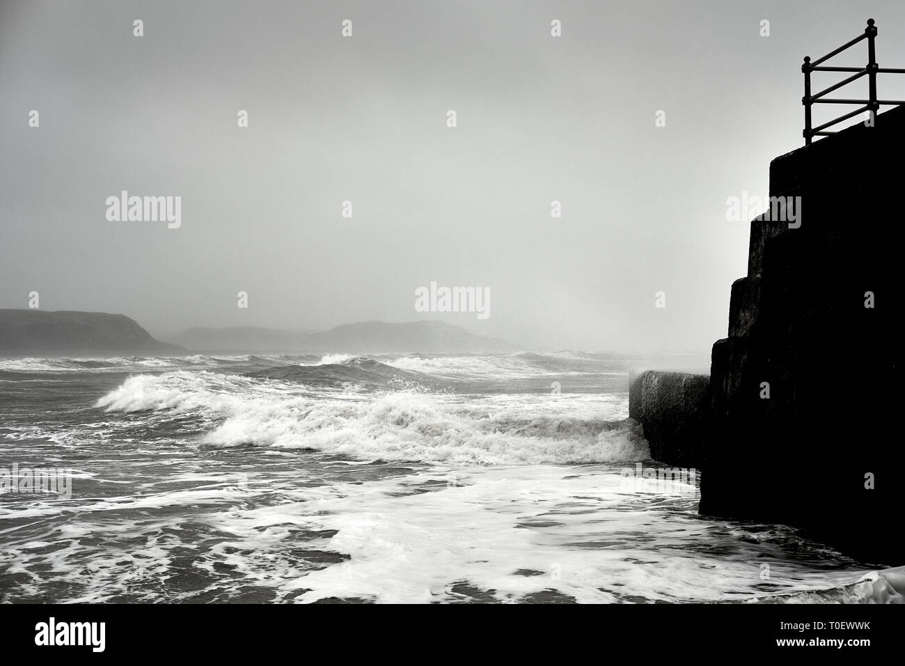Les vagues déferlent au-delà du brise-lames dans Cricceith dans le Nord du Pays de Galles comme Hannah tempête passe. Banque D'Images