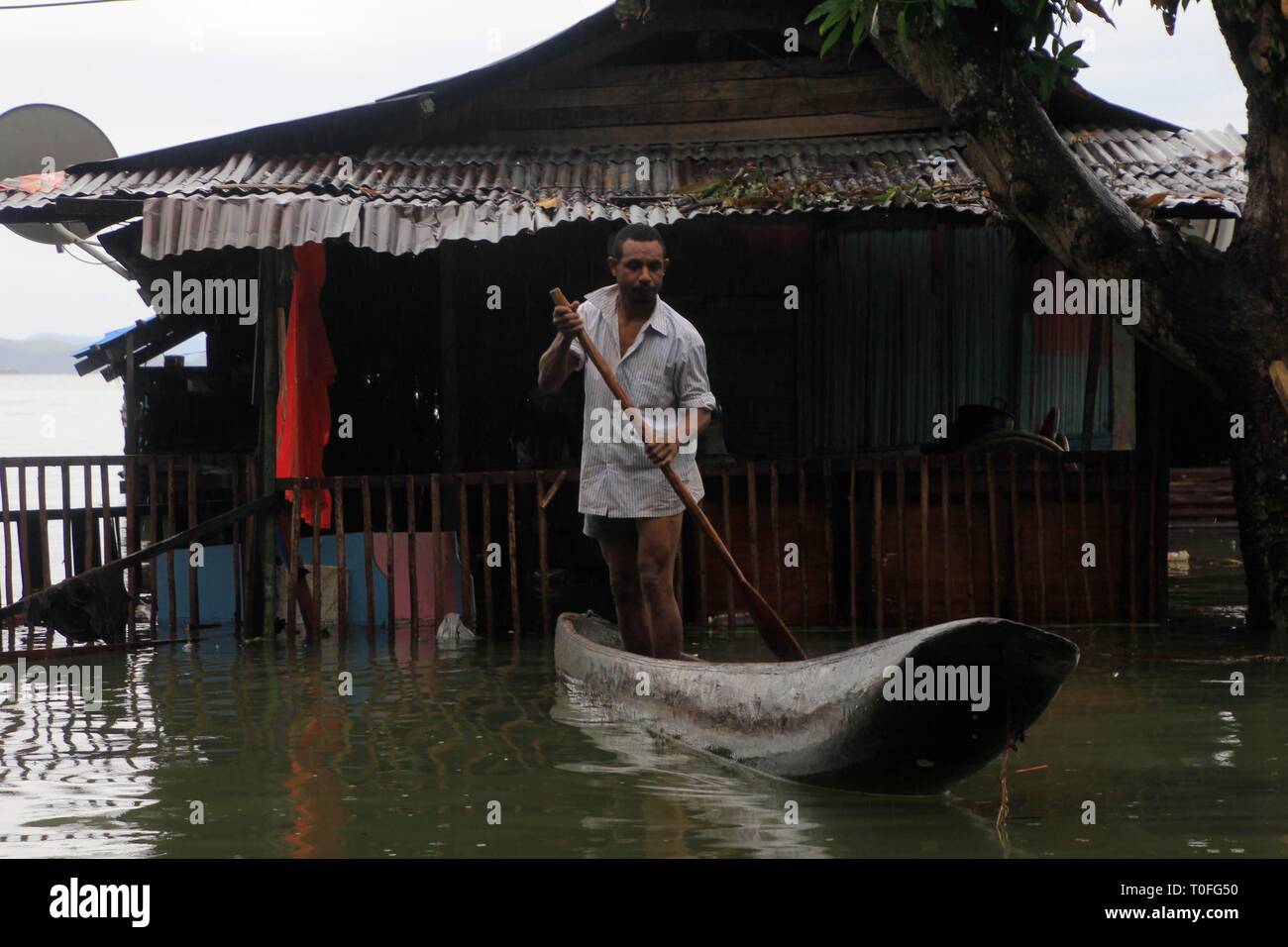 Sentani, Indonésie. Mar 19, 2019. Un homme monte un bateau dans l'eau d'inondation dans la région de Sentani, la province de Papouasie, Indonésie, le 19 mars 2019. Les autorités indonésiennes ont mis le sinistre bilan des crues éclair et des glissements de terrain dans l'est de la province de Papouasie à 89 alors que l'opération de recherche et sauvetage pour 74 personnes disparues continue, a dit qu'ici mardi. Credit : Ikha/Xinhua/Alamy Live News Banque D'Images