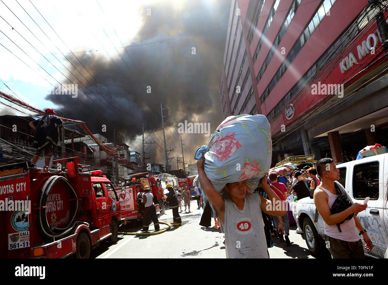 Quezon City, Philippines. Mar 20, 2019. Évacuer les résidents que leurs maisons sont la proie des flammes durant un incendie dans un bidonville à Quezon City, Philippines, le 20 mars 2019. Plus de 250 chantiers ont été rasées dans le feu, laissant 750 familles sans abri. Credit : Rouelle Umali/Xinhua/Alamy Live News Banque D'Images