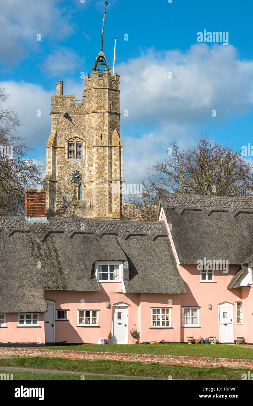 Thatched cottage peint en rose Suffolk avec Saint Mary's Church la Vierge sur la place du village. Cavendish, Suffolk, East Anglia, Royaume-Uni. Banque D'Images