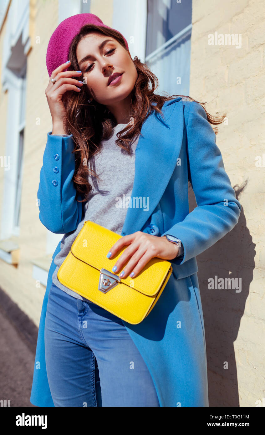 Jeune femme tenant un sac à main jaune et portant manteau bleu à la mode.  Femme printemps Vêtements et accessoires. Fashion Photo Stock - Alamy