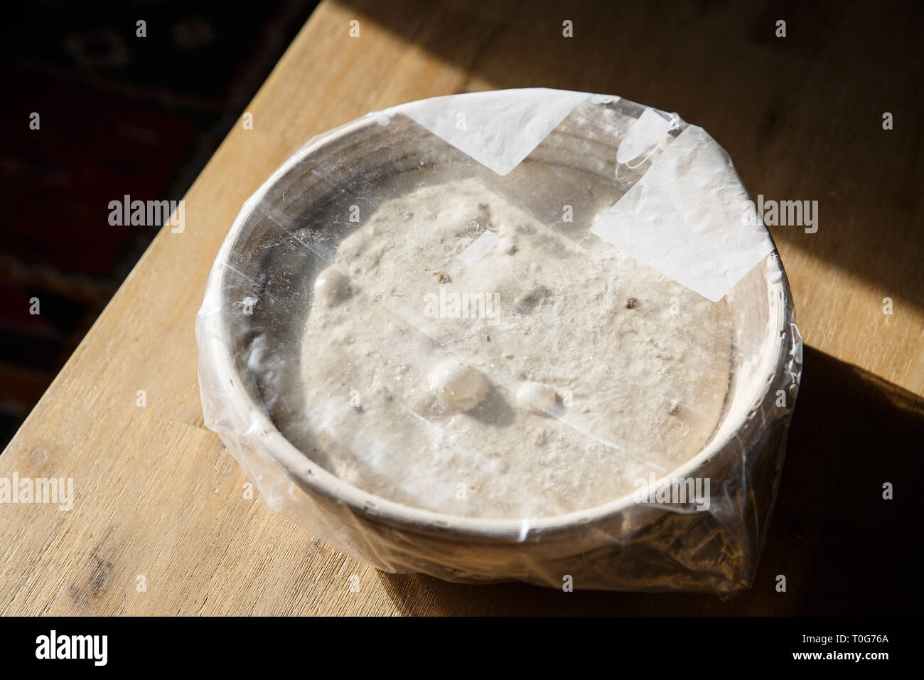 Levage du pain au levain dans un panier recouvert de film