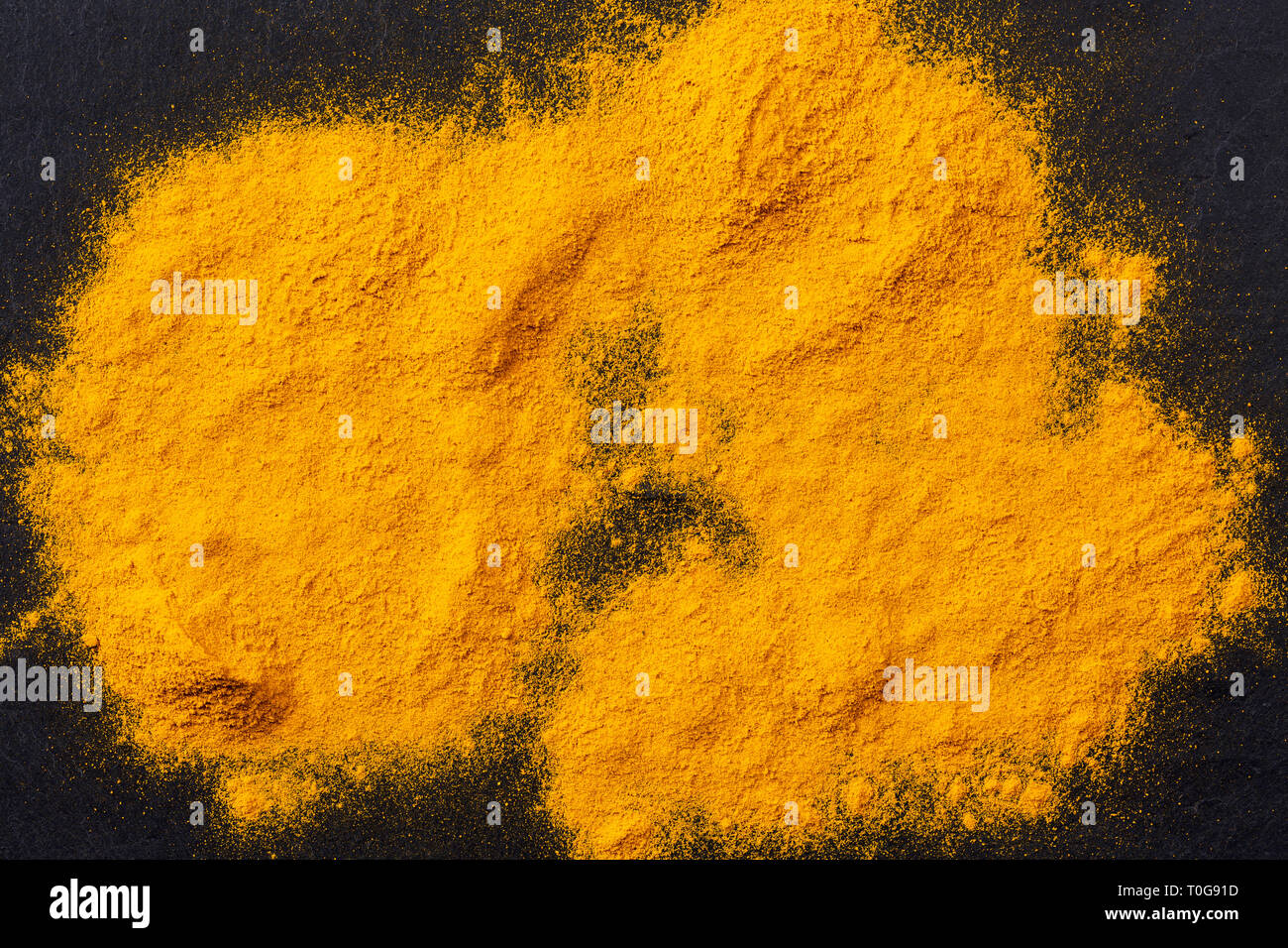 Des tas d'épices curcuma curcuma noir foncé sur fond ardoise, vue du dessus Banque D'Images