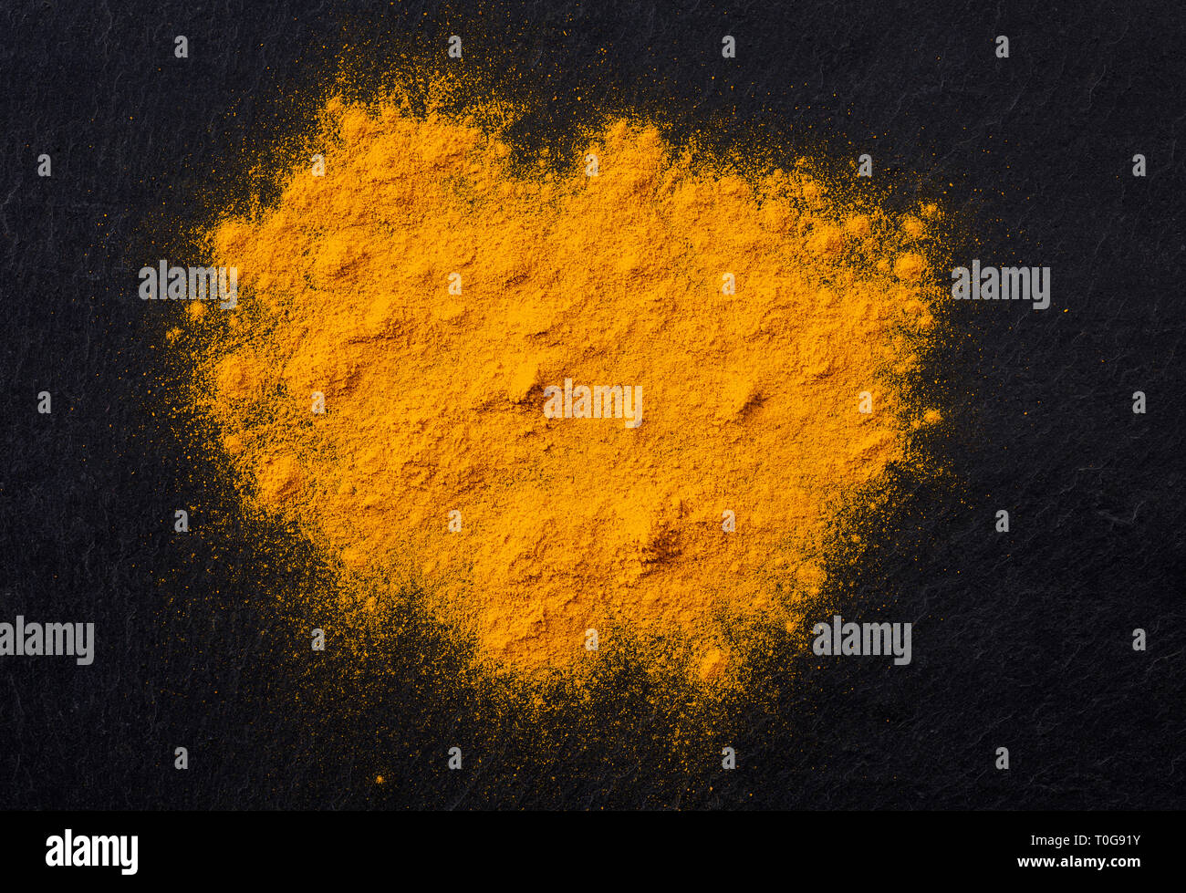 Des tas d'épices curcuma curcuma noir foncé sur fond ardoise, vue du dessus Banque D'Images