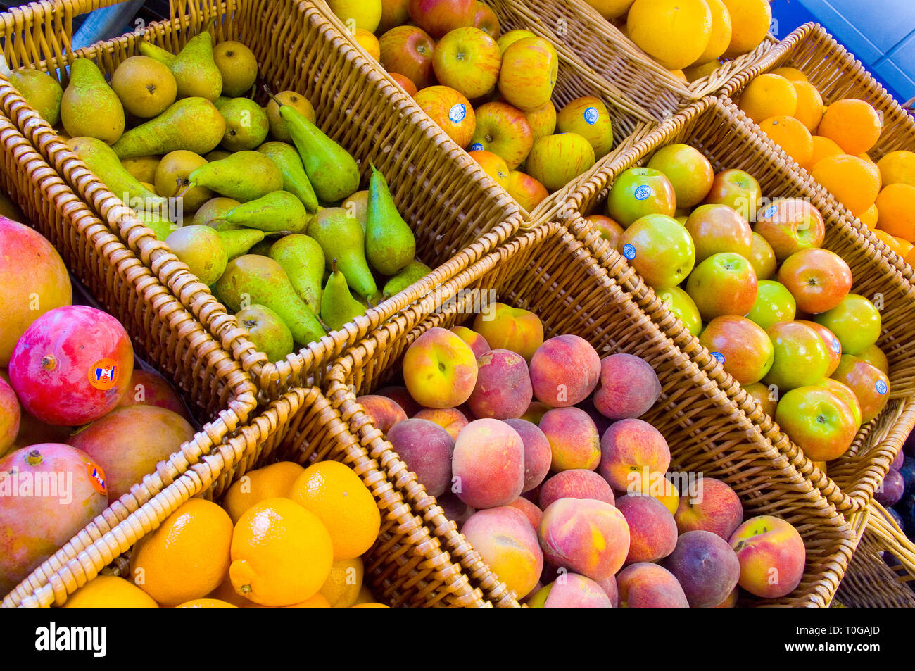 Différents paniers de fruits différents pour la vente dans un magasin vert. Banque D'Images