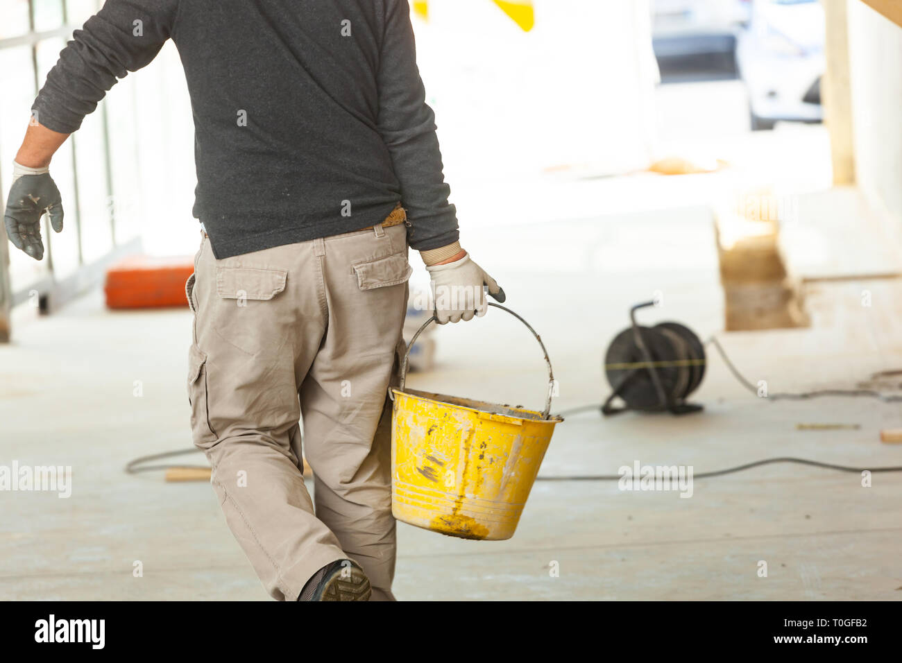 Travailleur de la construction au mortier de ciment sur le chantier de construction. Banque D'Images