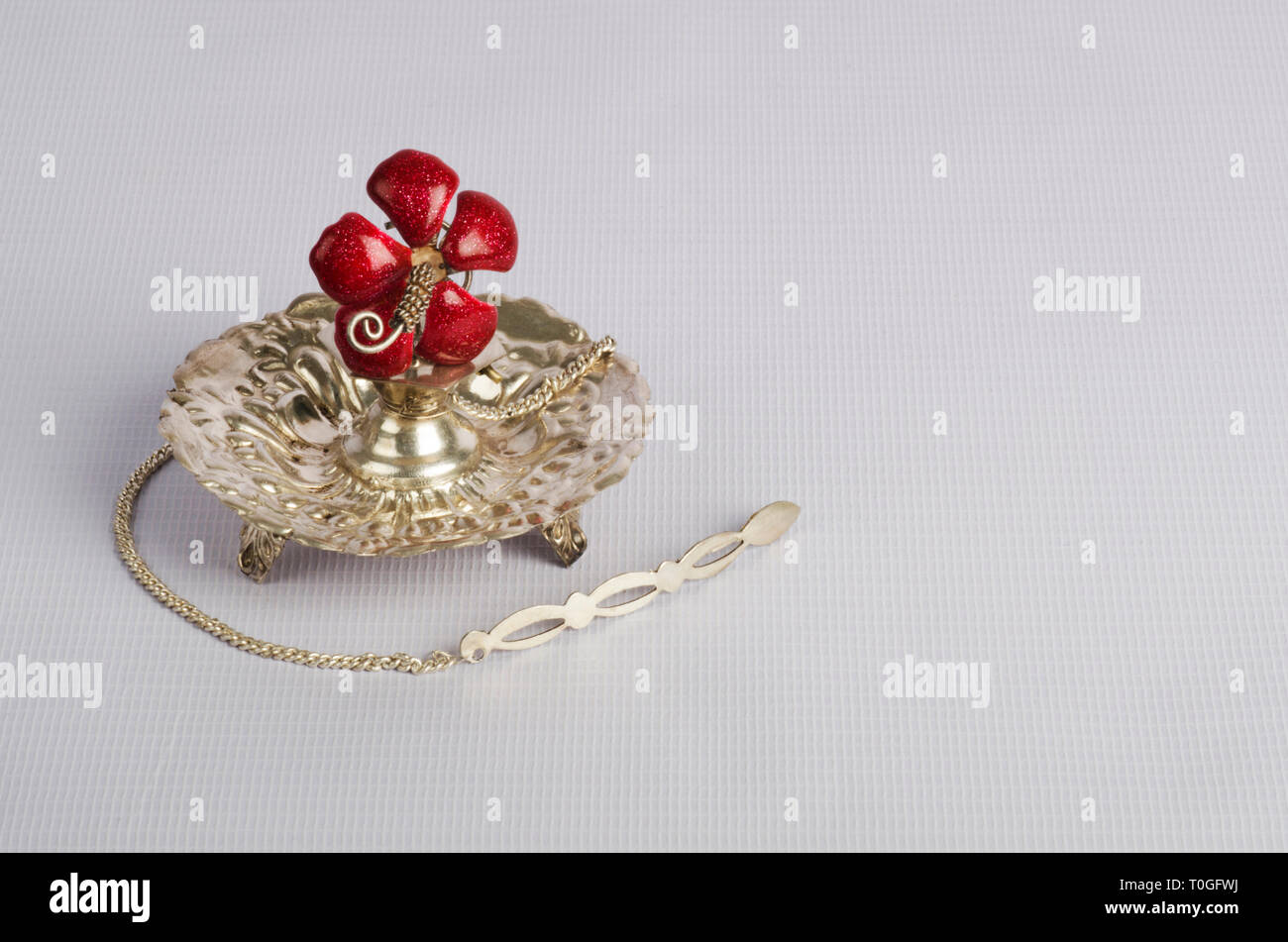 'Argent traditionnel Attardani» ou récipient de parfum sur fond de couleur blanc et rose rouge fleur artificielle aussi fait de l'argent. Banque D'Images