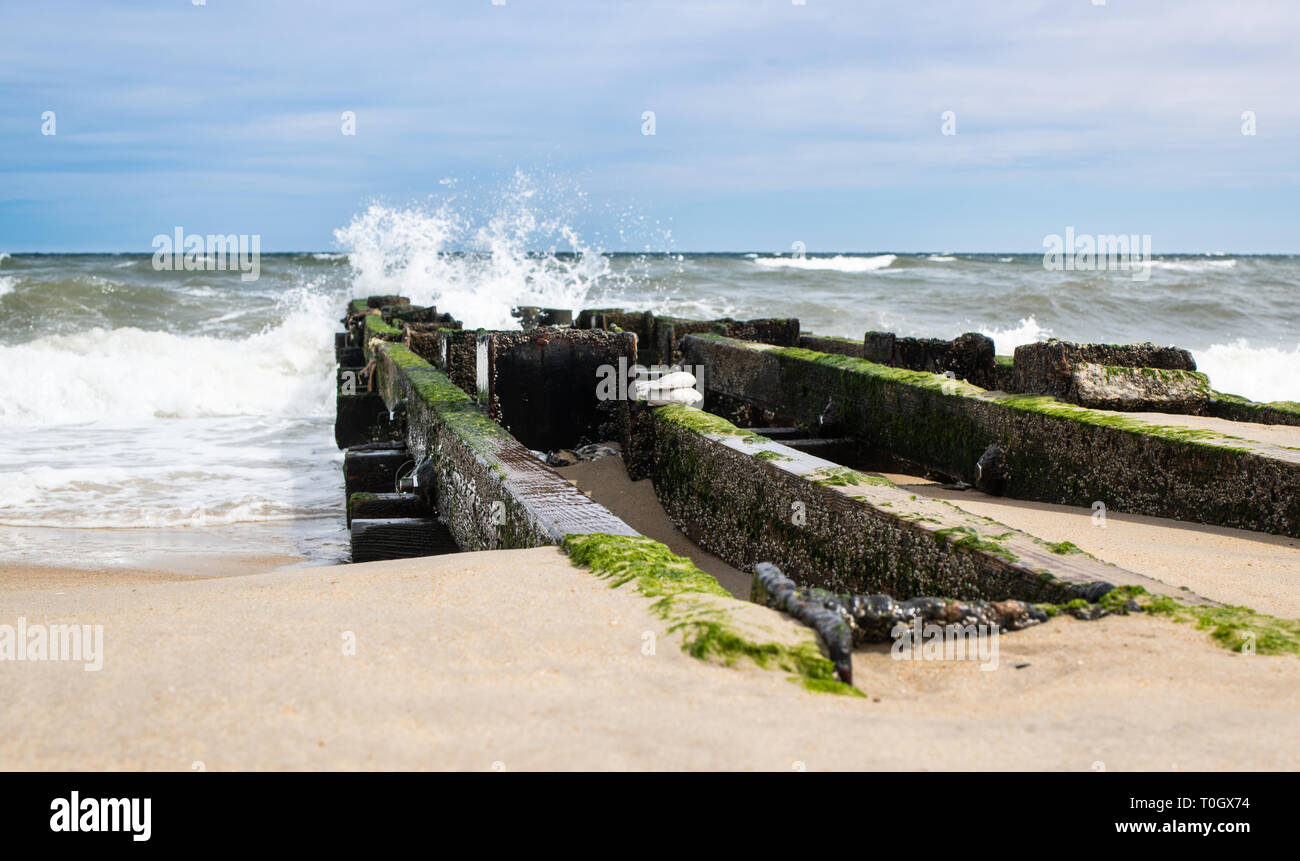 Les projections d'eau contre un brise-lames dans les Outer Banks de Caroline du Nord. Banque D'Images