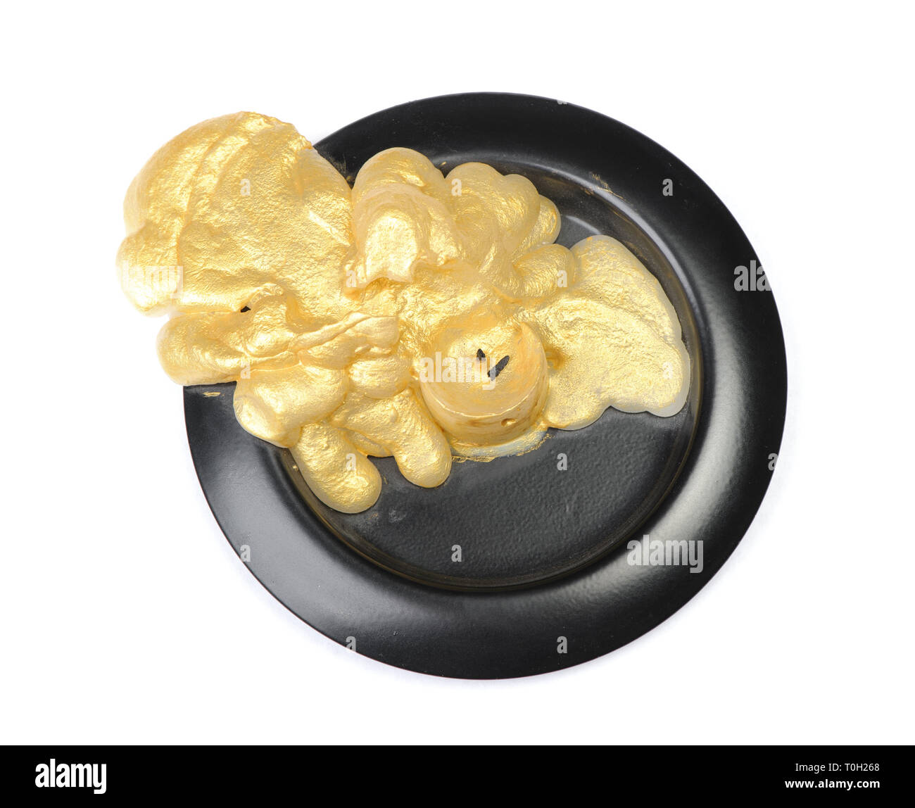 Vieille bougie de cire d'or sur un socle noir sur fond blanc isolé Banque D'Images