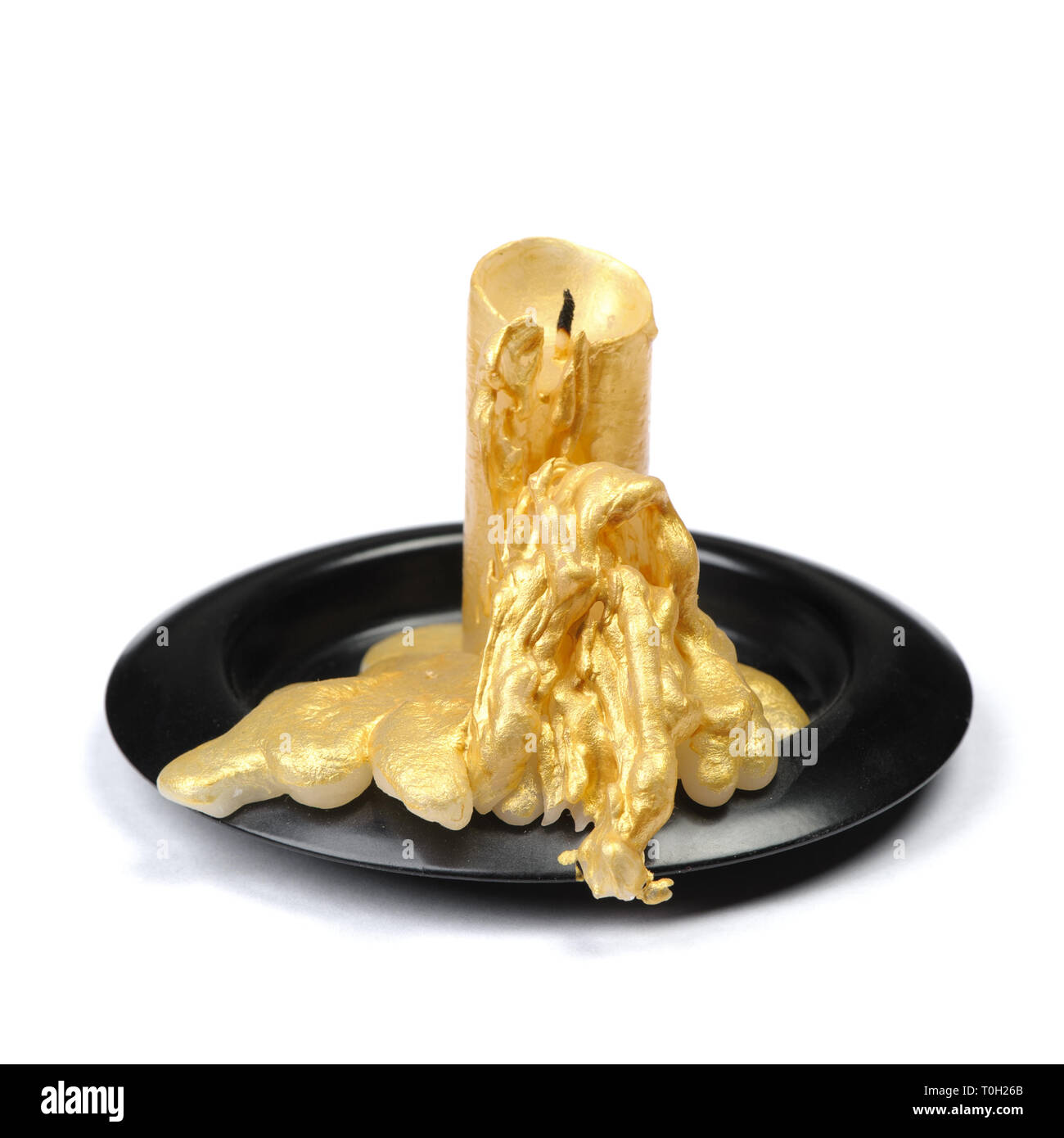 Vieille bougie de cire d'or sur un socle noir sur fond blanc isolé Banque D'Images