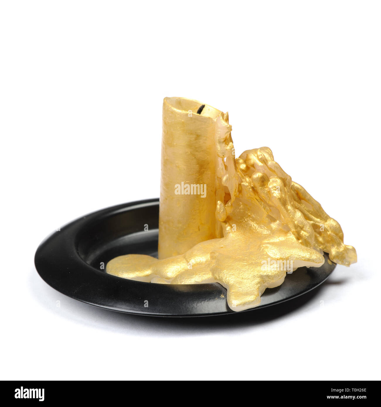 Vieille bougie de cire d'or sur un socle noir sur fond blanc isolé Banque D'Images