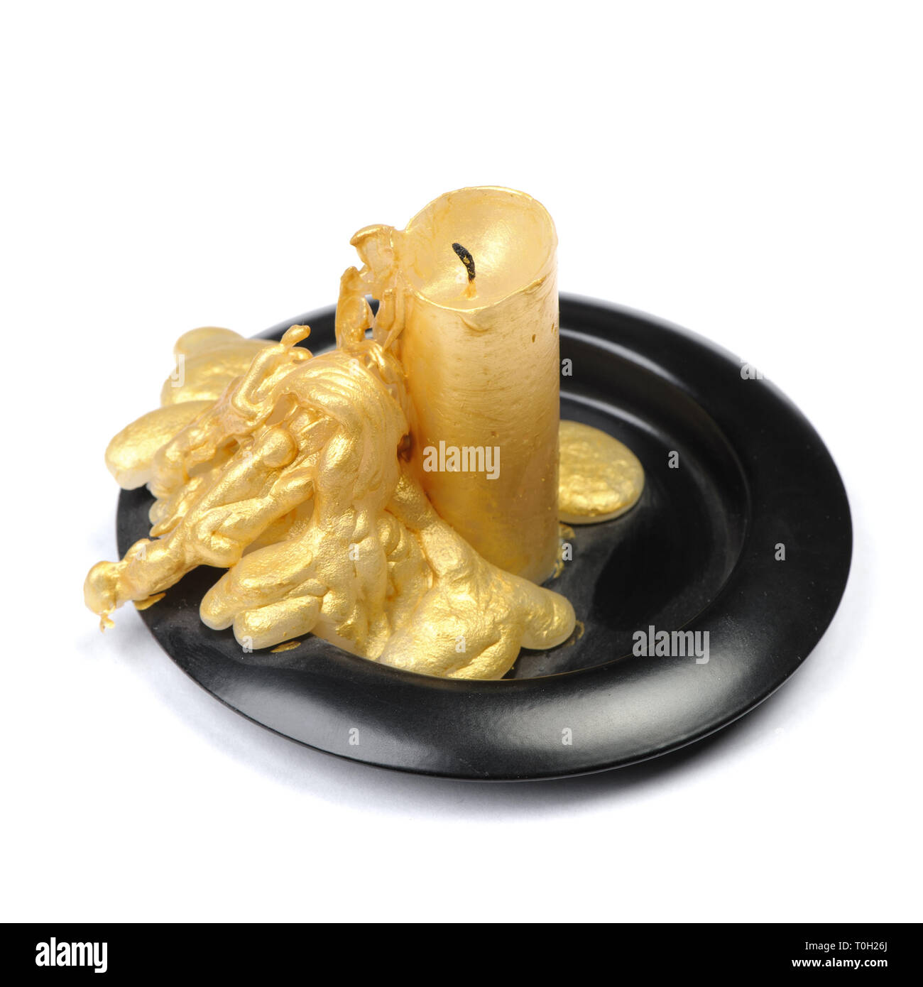 Vieille bougie de cire d'or sur un socle noir sur fond blanc isolé Banque D'Images