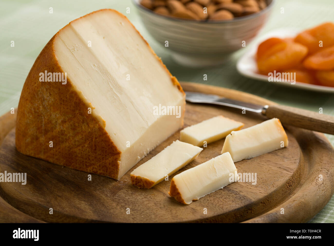 Morceau de fromage de brebis Français et des tranches sur une planche à découper Banque D'Images