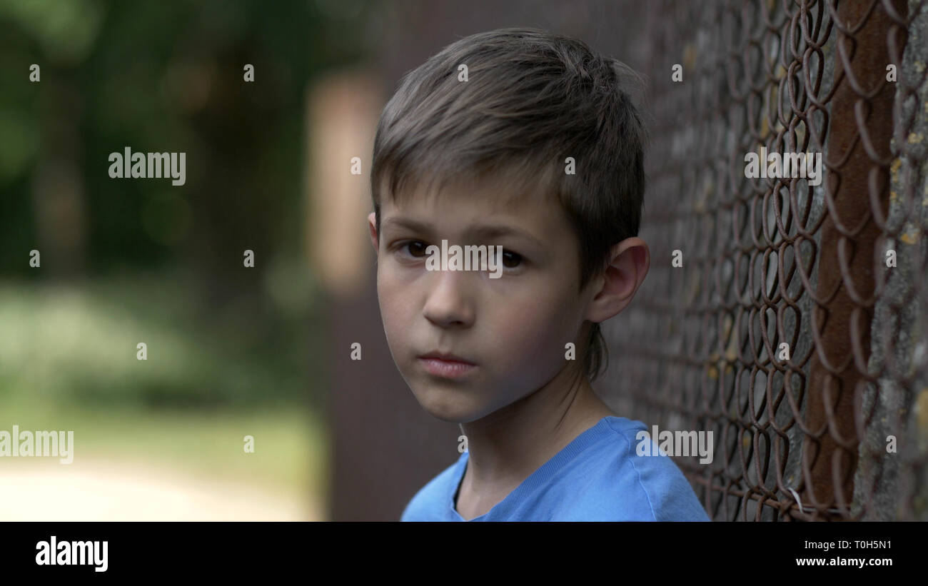 Portrait of a Lonely Boy a l'air dans l'appareil photo avec la douleur sur le visage Banque D'Images
