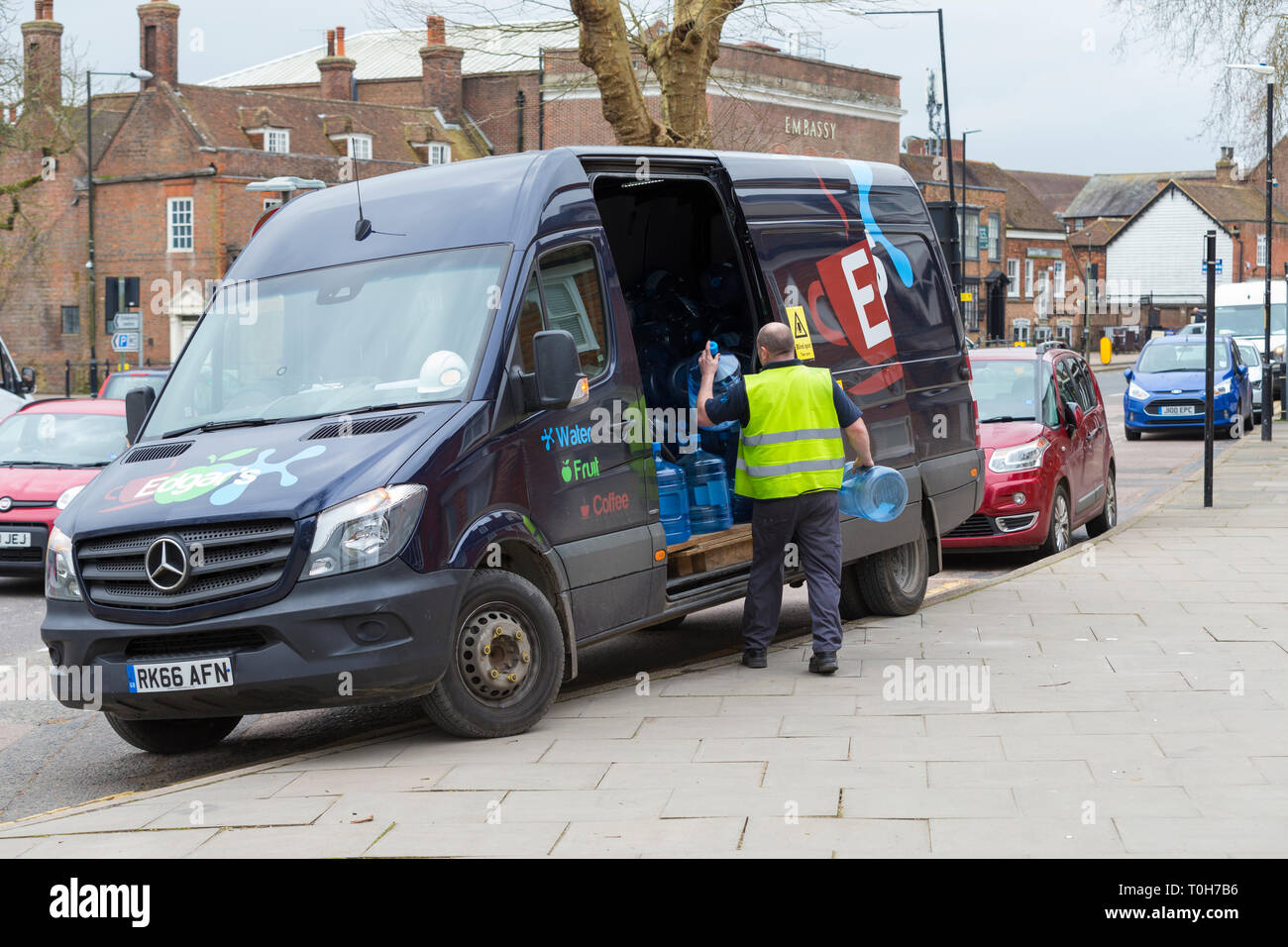 Chauffeur de livraison avec bureau vide des conteneurs d'eau, uk Banque D'Images