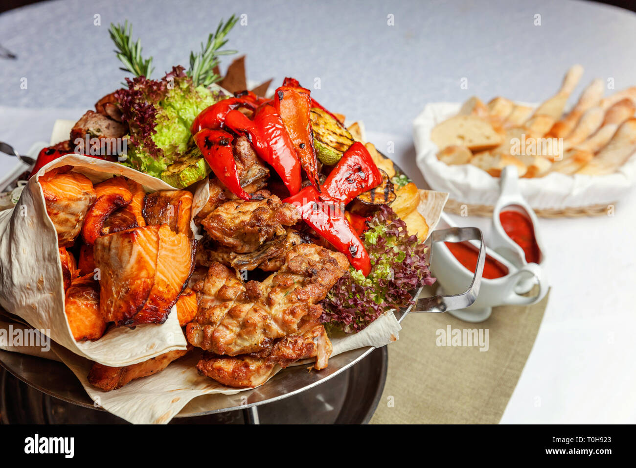 Grillade de viande, légumes et filets de poisson grillés, décoration à plat chaud. Un assortiment de délicieux kebab grillé servi avec des herbes sur plat Banque D'Images