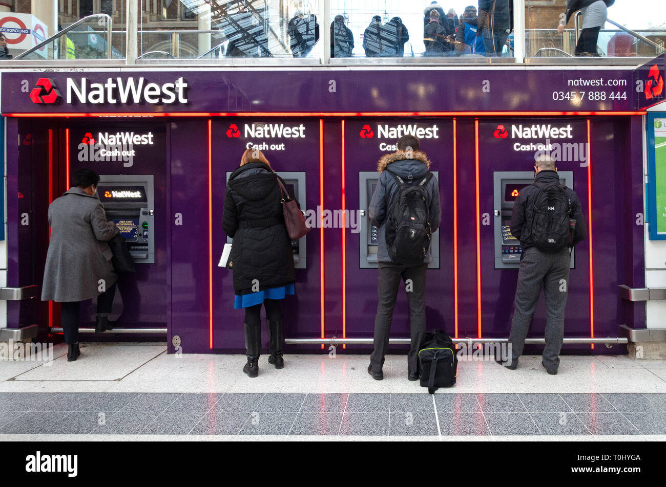 Les gens à l'aide de distributeurs automatiques de billets situé dans une rangée de Nat West Bank ATM's dans le hall principal de la gare de Liverpool Street, Londres Banque D'Images