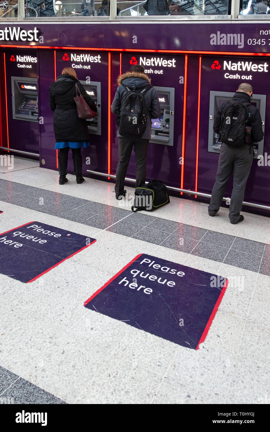 Les gens à l'aide de distributeurs automatiques de billets situé dans une rangée de Nat West Bank ATM's dans le hall principal de la gare de Liverpool Street, Londres Banque D'Images