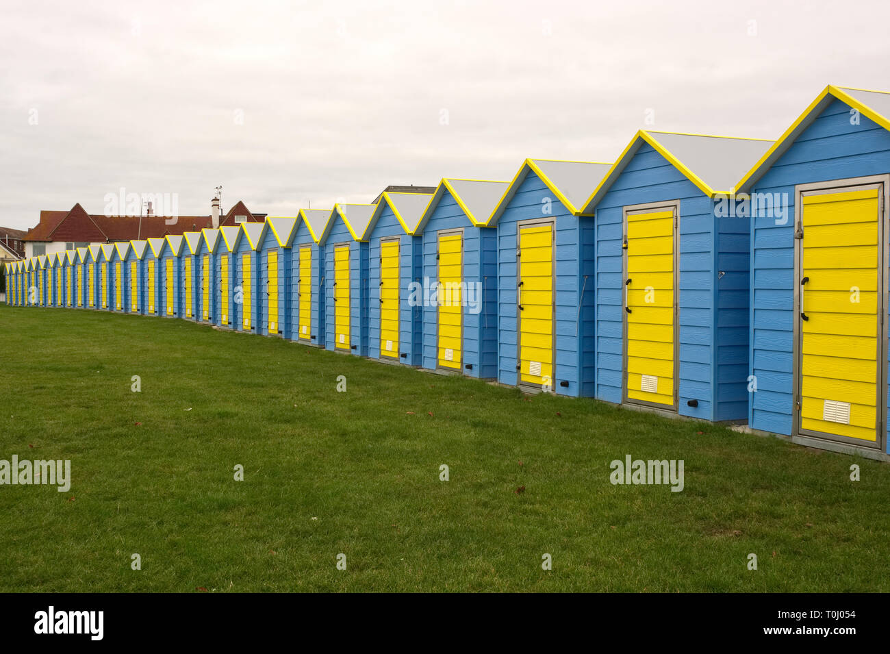 Cabines de plage bleu et jaune sur le front de mer à Littlehampton, West Sussex, Angleterre Banque D'Images