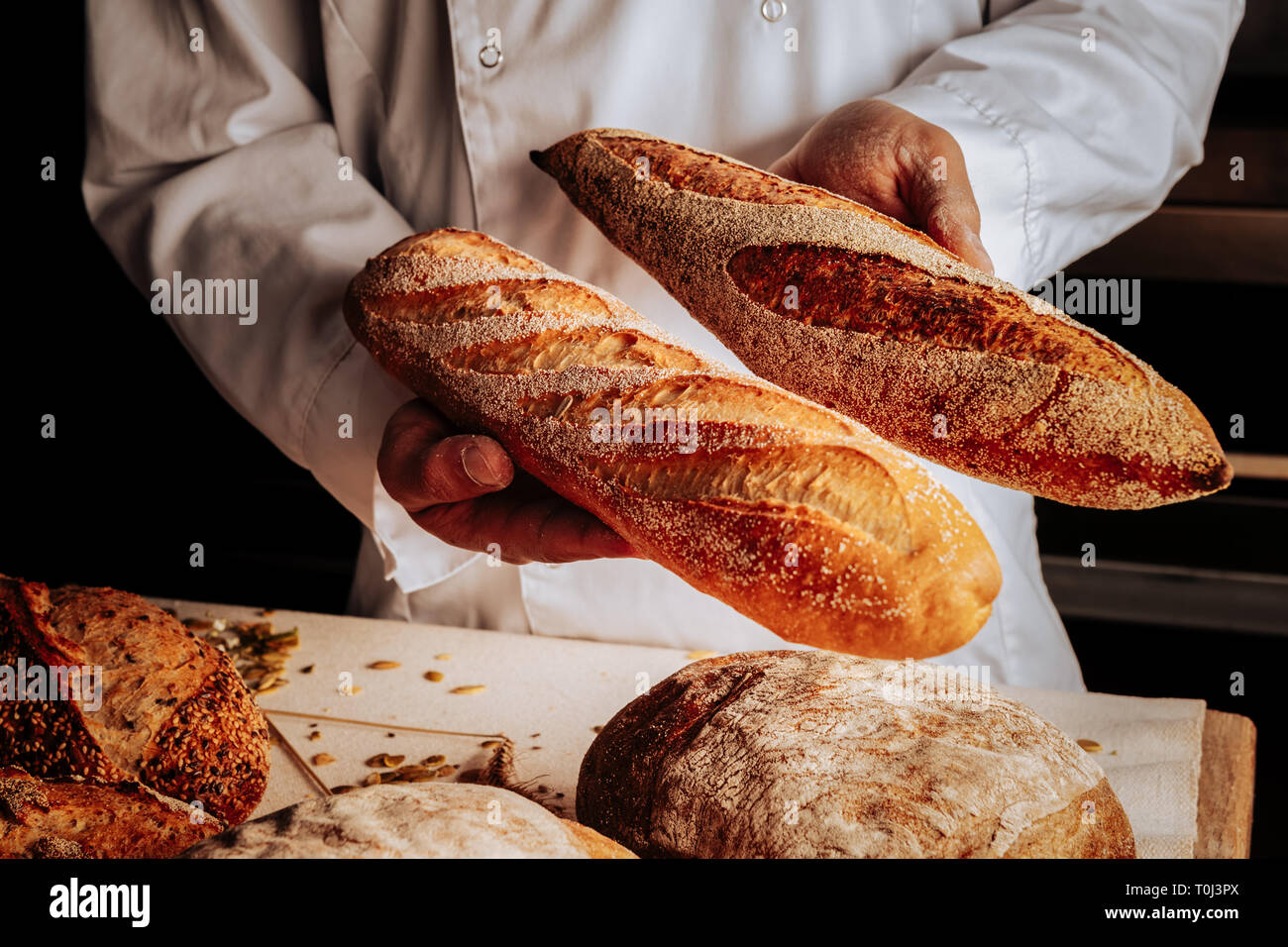 Le boulanger montrant peu de blé et de seigle, baguettes Banque D'Images
