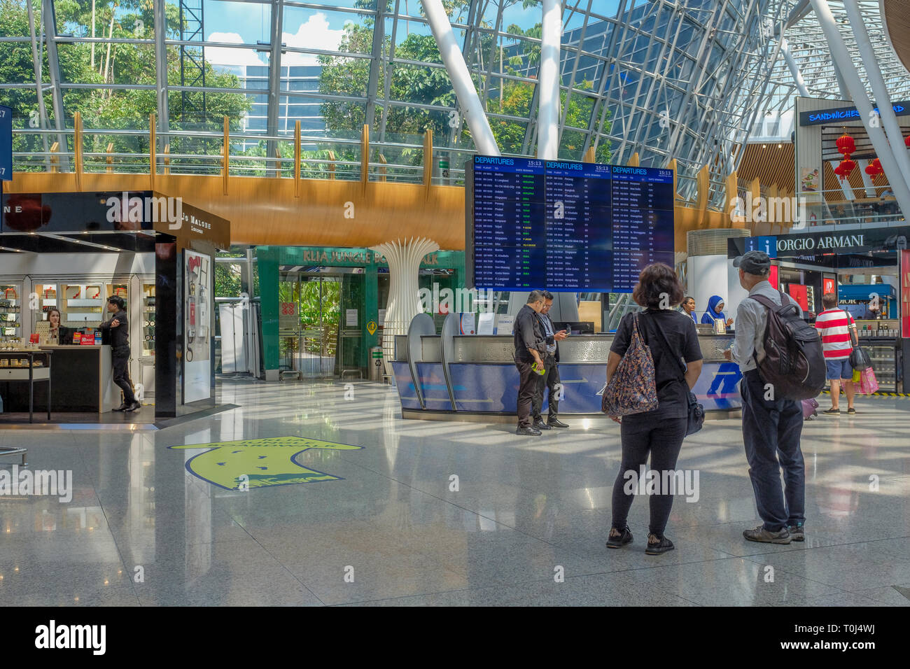 Les voyageurs internationaux vérifier leurs vols à l'Aéroport International de Kuala Lumpur. Banque D'Images